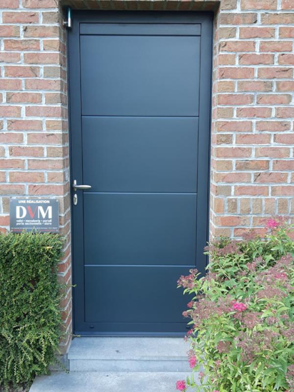 Porte de service en panneaux de porte sectionnelle rappelant la porte de garage gris 7016